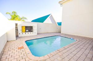 a swimming pool in the middle of a patio at Spekboom Beach Apartments in Jeffreys Bay