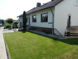 une maison avec une pelouse verte devant elle dans l'établissement Casa Graf, à Bad Emstal