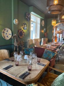 a restaurant with a long table with glasses on it at Hôtel des Pins in Jullouville-les-Pins