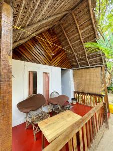 a porch of a house with chairs and a table at DucknChill-Agonda in Agonda