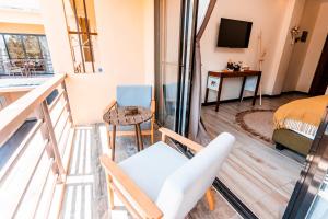 Pokój z balkonem z krzesłem i telewizorem w obiekcie Molly Resorts w mieście Puerto Galera