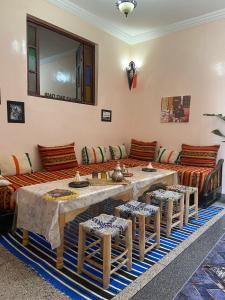 een woonkamer met een tafel en een bank bij Riad dar sahrawi in Marrakesh