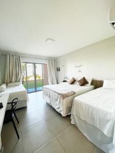 Habitación de hotel con 2 camas y ventana en Locanda dei Venti, en Itarema