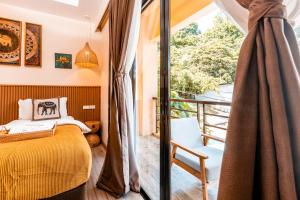 a bedroom with a yellow bed and a balcony at Molly Resorts in Puerto Galera