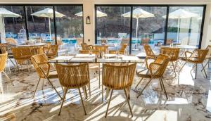 a dining room with a table and chairs and windows at Green Bay in Limenaria