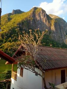 a house with a mountain in the background at Sunrise guest house in Nongkhiaw