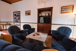 a living room with blue chairs and a table at Solar de Lalém in Maia