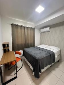 a bedroom with a bed and a table and a chair at apê 1108, mandarim belém, 11º andar-wifi-garagem in Belém