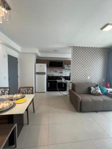 a living room and kitchen with a couch and a table at apê 1108, mandarim belém, 11º andar-wifi-garagem in Belém