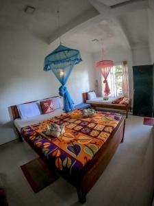 a bedroom with a large bed with a colorful blanket at 9 Arch view rest inn in Ella