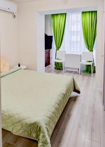 a bedroom with a large bed with green curtains at Комфортная студия на Южном вокзале in Kharkiv