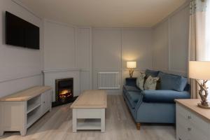 uma sala de estar com um sofá azul e uma lareira em The Glencoe Inn em Glencoe
