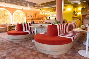 a restaurant with two chairs with red and white seats at ibis Istres Trigance in Istres