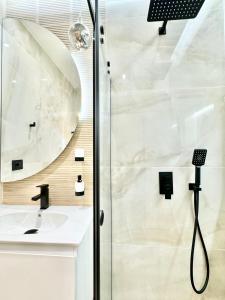ein Bad mit einer Dusche und einem Waschbecken in der Unterkunft City Modern & Classy Apartment for 4 Guests & Parking in Sofia
