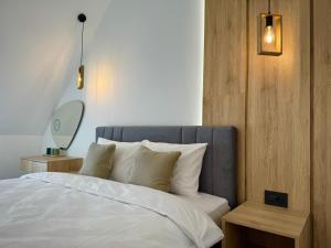 Schlafzimmer mit einem Bett mit weißer Bettwäsche und Kissen in der Unterkunft City Modern & Classy Apartment for 4 Guests & Parking in Sofia