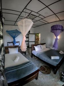 een slaapkamer met 2 bedden en paarse gordijnen bij 9 Arch view rest inn in Ella