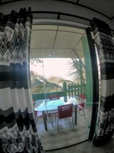 een glazen deur met een tafel en stoelen op een patio bij 9 Arch view rest inn in Ella