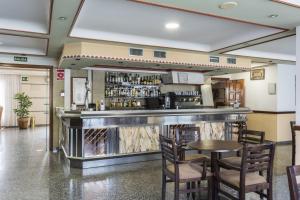 a bar in a restaurant with a table and chairs at Hotel Nuevo Vichona Spa 3 estrellas Superior in Sanxenxo