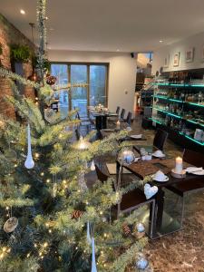 un albero di Natale in una stanza con tavoli e sedie di The Rooms Lytham a Lytham St Annes