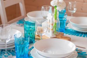 a table with blue and white plates and wine glasses at Morska Przystań Darłówko in Darłówko
