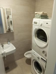 ein Badezimmer mit einer Waschmaschine und einem Waschbecken in der Unterkunft Apartman City BL in Banja Luka