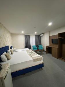 a hotel room with a large bed and blue chairs at Nostalji Hotel in Avcılar