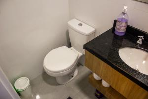 a bathroom with a white toilet and a sink at Studio no centro de Curitiba in Curitiba