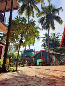 a resort with palm trees and a playground at ArtKarna in Gokarna