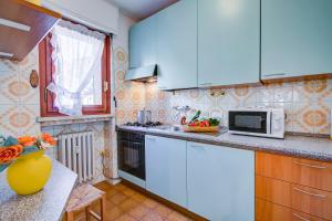 una cucina con armadi blu e forno a microonde di Snow White - Happy Rentals a Bardonecchia