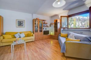 ein Wohnzimmer mit 2 Sofas und einem TV in der Unterkunft Snow White - Happy Rentals in Bardonecchia