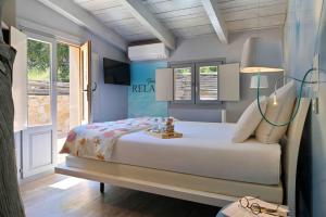 a bedroom with a bed with a lamp and a window at Hôtel Domaine A Flatta in Calenzana