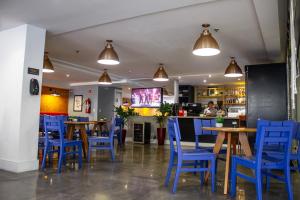 a restaurant with blue chairs and tables at Studio no centro de Curitiba in Curitiba