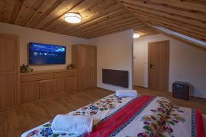 a bedroom with a large bed and a flat screen tv at Koliba pod Vlkolíncom in Ružomberok