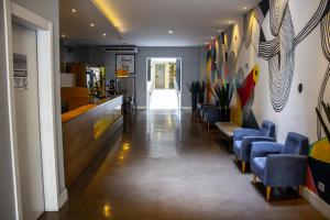 a waiting room with blue chairs and a bar at Studio no centro de Curitiba in Curitiba