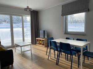 ein Wohnzimmer mit einem Esstisch und Stühlen in der Unterkunft Apartamenty Spalona Sport in Spalona