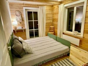 een bed in een kamer met houten wanden en ramen bij Holiday homestead Camp of Forest Souls 