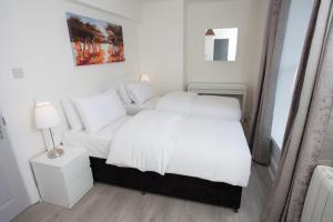 a bedroom with a white bed and a couch at Temple Bar Essex Apartments in Dublin