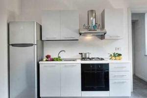 een keuken met witte kasten en een koelkast bij Sorrento Capo Light Blue in Sorrento