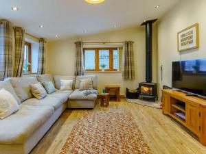 a living room with a couch and a tv and a fireplace at 2 Bed in Usk 87285 in Llandenny