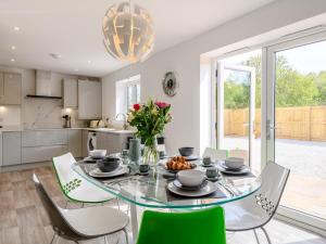 a kitchen and dining room with a glass table and chairs at 3 bed in Blue Anchor 87069 in Withycombe