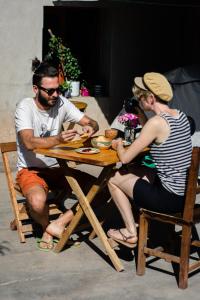 Eine Gruppe von Menschen, die an einem Tisch sitzen und Essen essen. in der Unterkunft Acusi Hostel Camping in Humahuaca