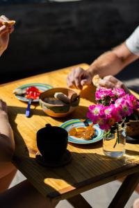 una mesa con platos de comida y flores. en Acusi Hostel Camping en Humahuaca