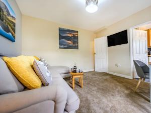 een woonkamer met een bank en een tv bij 2 Bed in Cockermouth 87481 in Cockermouth