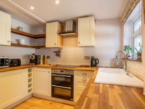 una cucina con armadi bianchi e lavandino di 2 bed in Oulton 88109 a Lowestoft