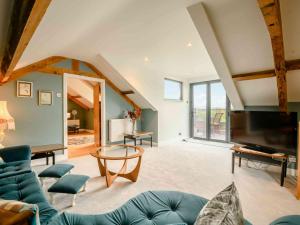 a living room with a blue couch and a tv at 5 Bed in Carlisle 87447 in Scotby