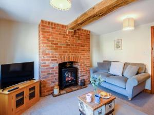 sala de estar con sofá y chimenea en 3 bed property in Mattishall 88569 en Yaxham