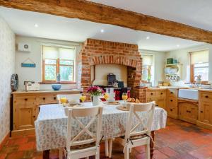 a kitchen with a table and chairs and a brick wall at 3 bed property in Mattishall 88569 in Yaxham