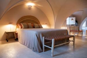 a bedroom with a bed and a bench in a room at Antica Masseria le Monache in Grottaglie