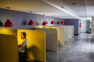 a man sitting at a yellow counter in a restaurant at Studio no centro de Curitiba in Curitiba