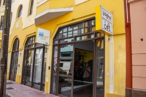 a yellow building with a sign for a store at Studio no centro de Curitiba in Curitiba
